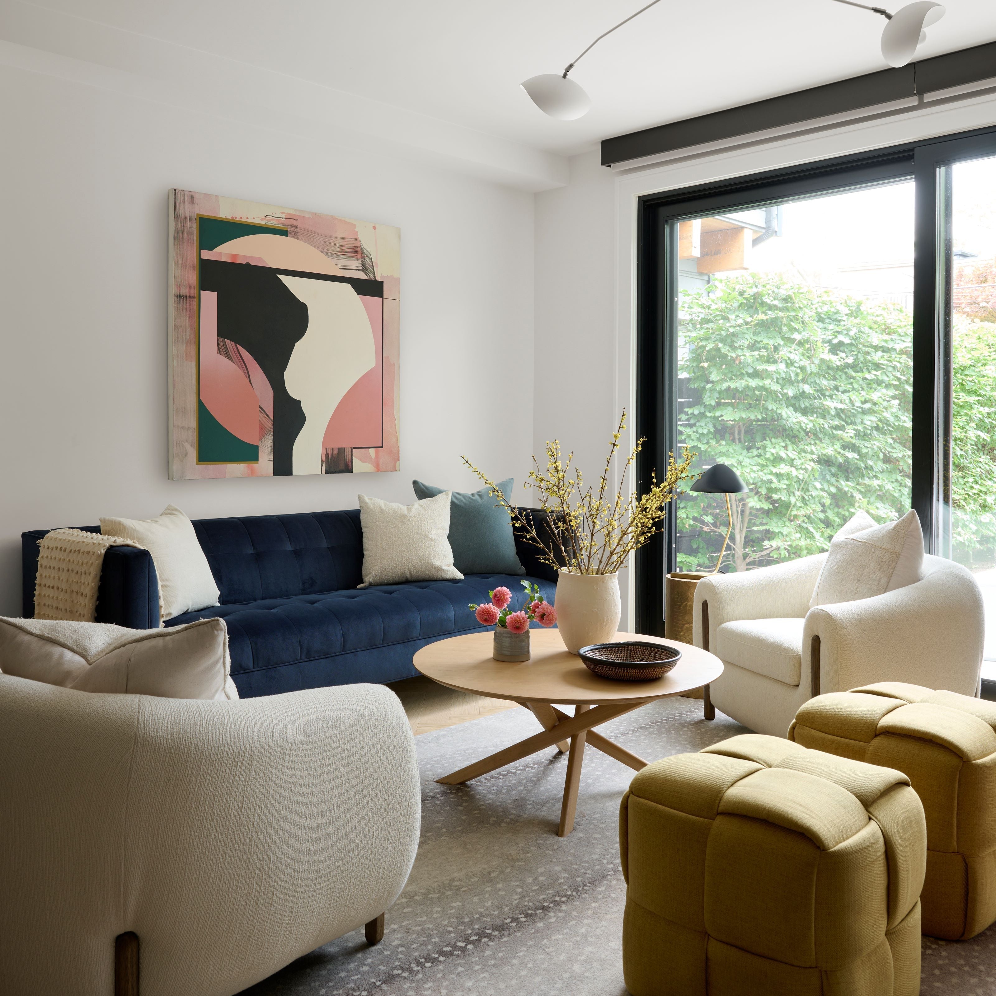 Living Room Interior By Homekin Featuring Navy Blue couch and Cushions and a Side chair with nice wall art and glass windows