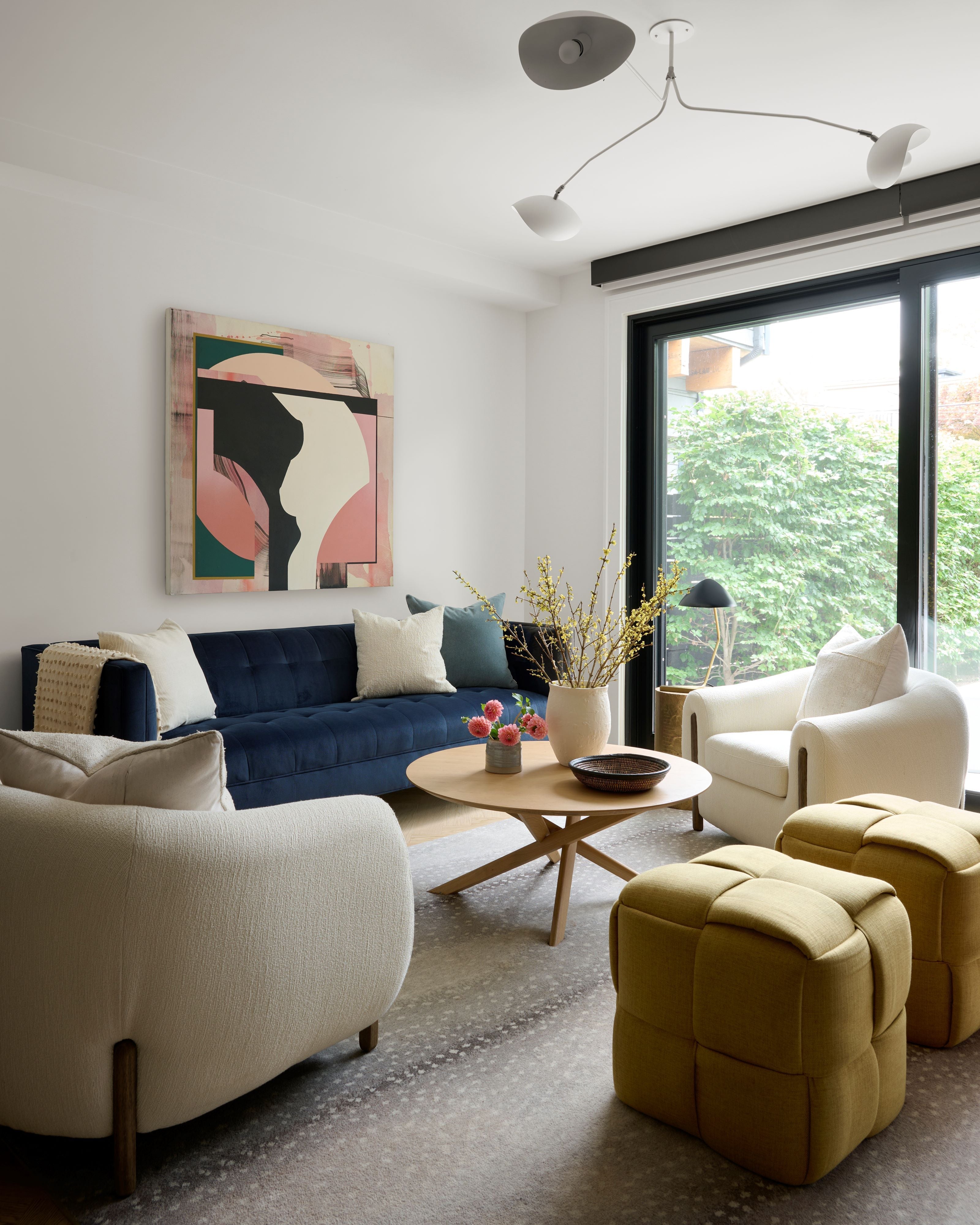 Living Room Interior By Homekin Featuring Navy Blue couch and Cushions and a Side chair with nice wall art and glass windows