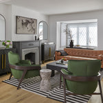 Contemporary living room with black and white stripe rug hunter green velvet accent chairs black cement coffee table and cognac leather tufted sofa