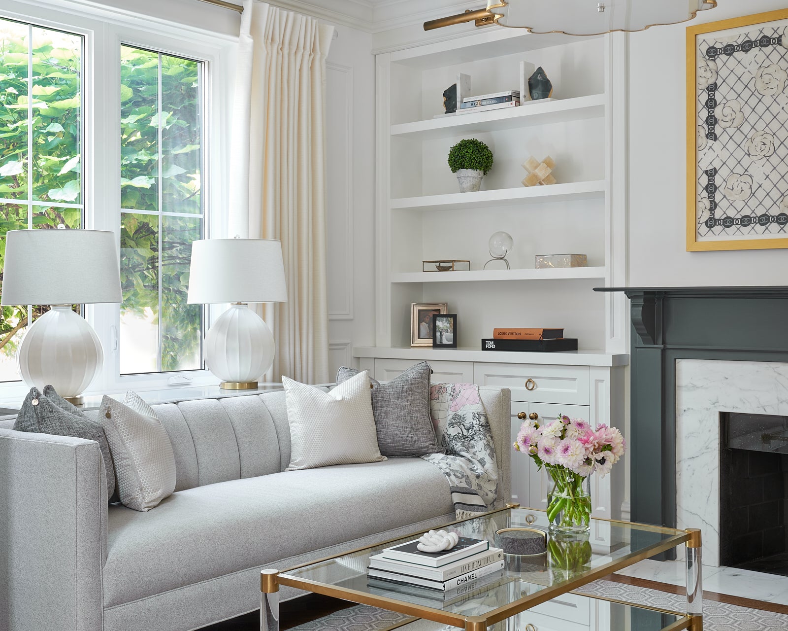 Elegant and sophisticated living room with feminine decor accents in brass and acrylic