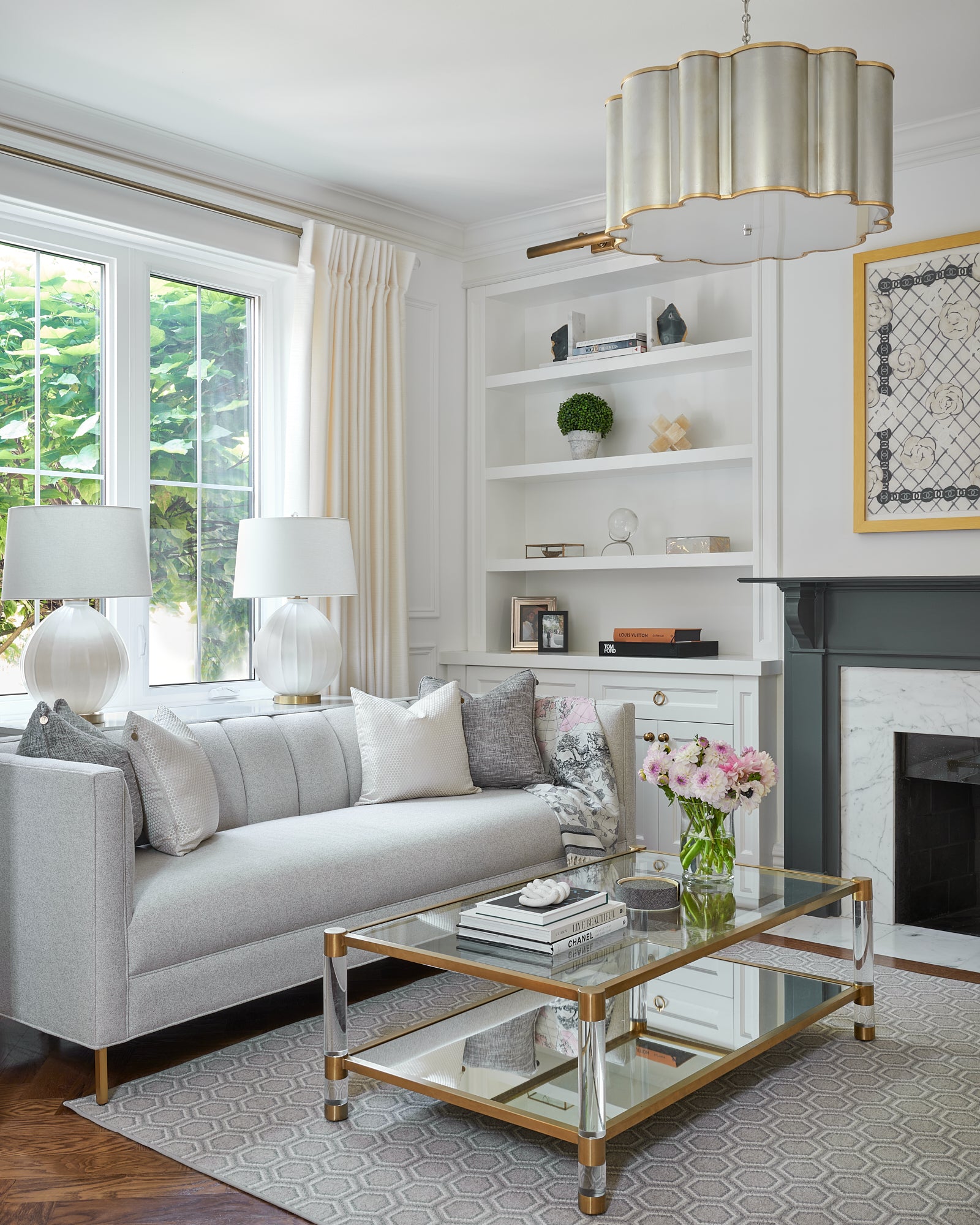 Elegant and sophisticated living room with feminine decor accents in brass and acrylic