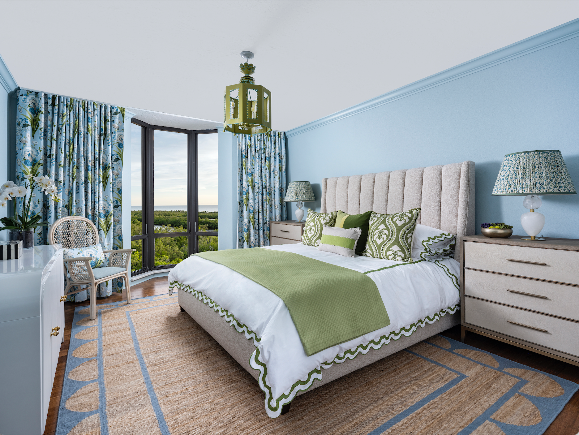 Colourful bedroom with scallop jute rug Matouk bedding and blue and green lantern with Thibaut drapery Florida coastal living