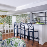 Green hollywood palm wallpaper with coral style dining chairs and gold palm chandelier Naples Florida home colorful playful style decor navy blue lacquer counter stools Chippendale style