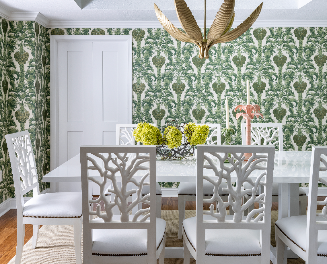 Green hollywood palm wallpaper with coral style dining chairs and gold palm chandelier Naples Florida home colorful playful style decor